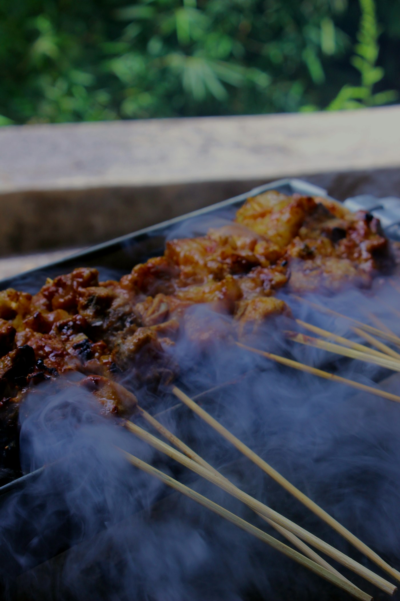 Tusukan sate maranggi daging sapi berbumbu ketumbar mengepul di atas pembakaran arang