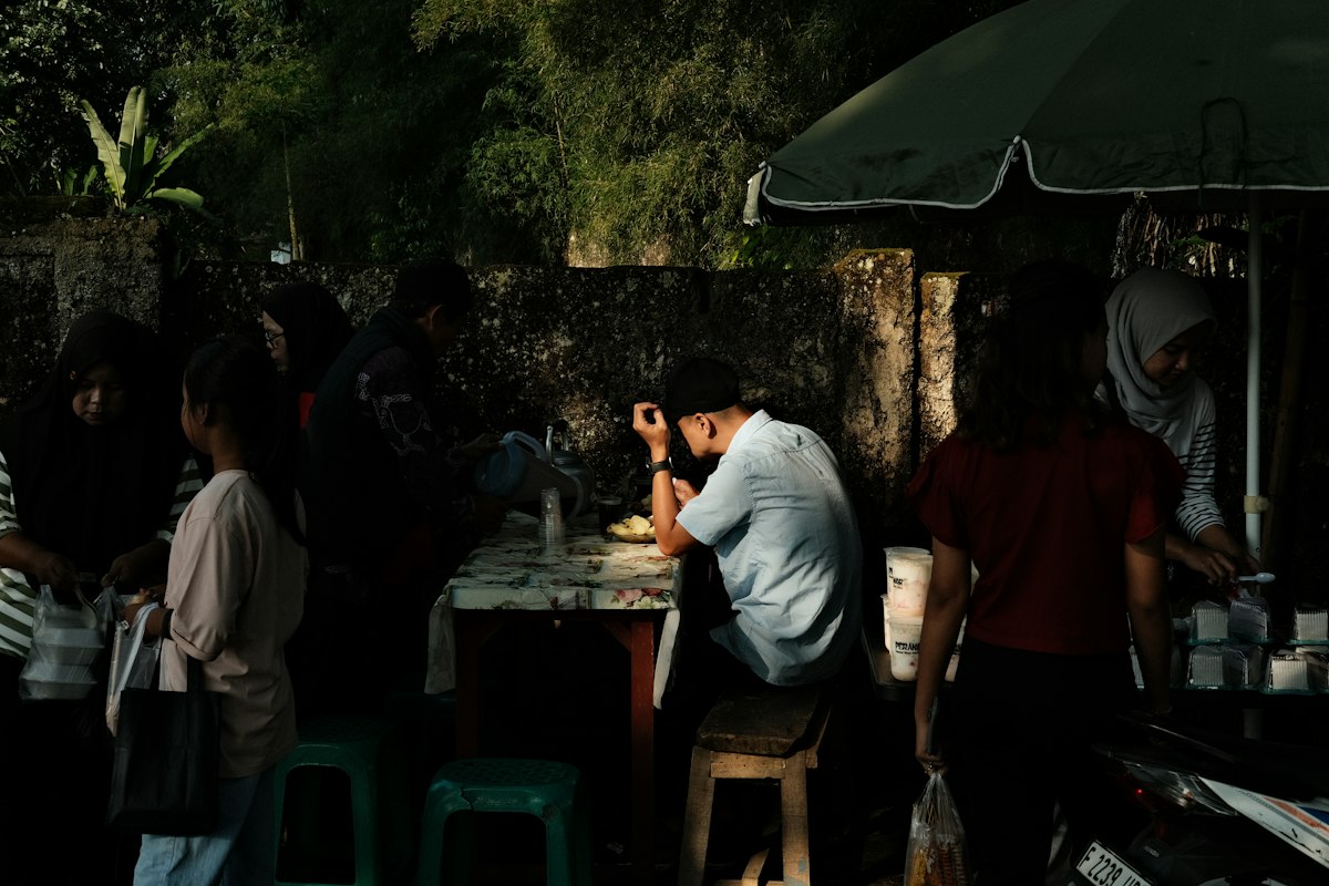 Suasana warung kaki lima di Indonesia tempat pengunjung menikmati makanan